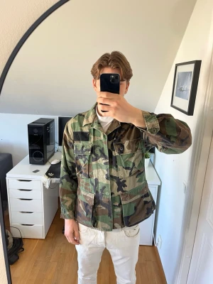 Camouflage overshirt jacka - Säljer en grön och brun camouflage overshirt jacka med klassisk krage och stora bröstfickor. Okänt märke. Hör gärna av dig vid frågor!