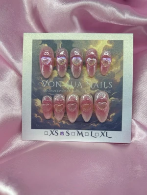 SweetBlush (S);Medium Almond - Handgjorda press-on naglar i rosa blush med glittereffekt och holografiska hjärtan. Naglarna har en en medium almondform och skimrar snyggt i ljuset. Perfekt för dig som vill ha en söt och trendig look. S: 15 mm, 11,5 mm, 12 mm, 11 mm, 9 mm 