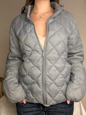 Ljusblå quiltad pufferjacka från part two🩵 - Snygg ljusblå pufferjacka med quiltat mönster och dragkedja framtill. Jackan har hög krage och två sidofickor. Perfekt för kalla dagar och ger en trendig look. Jackan ärvindtät och har en puffig, vadderad form. Finns en defekt på insida arm!🩵