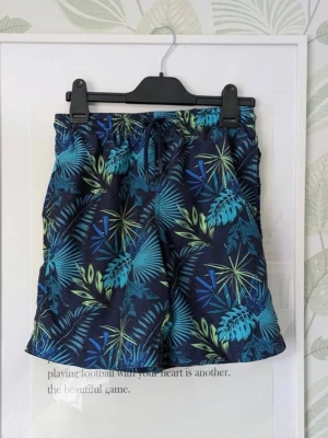 Badshorts Storlek 158/164 (152/158) Firefly - Från intersport. - I jättefint skick. - Det jag hittar att anmärka på är att det förekommer miniskavank bak på ena halvan på ett ställe, ljusare text i tvättlapp, lite skav i metallring vid midjesnöre och en liten tråd som sticker ut vid benkant, se extrabilderna . - Tycker den är liten i storlek så passar 158 eller en 152 om den ska vara lite större . - Se extrabilderna för att se skick. - Jag kan ha missat någon miniskavank men jag har försökt att granska plagget så gott det går.