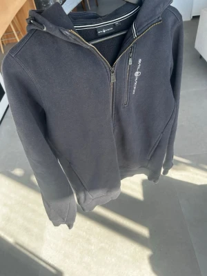 Svart hoodie från Sail Racing - Säljer en svart hoddie från Sail racing, väldigt bra passform och säljer för ett mycket bra pris💫 ny pros år 999kr och mitt pris går absolut att diskutera