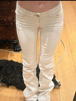 Vita bootcut jeans från Nelly - Säljer ett par vita bootcut jeans från Nelly med klassisk femficksdesign och snygg broderad detalj på bakfickan. Jeansen har normal midja och är tillverkade i stretchigt denimtyg för skön passform. Perfekta för dig som vill ha en clean och fräsch look.