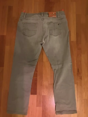 Grå jeans från Jacob cohen - Snygga grå jeans från Jacob Cohen med klassisk femficksmodell och raka/slim ben som ger en tapered look. Jeansen har en diskret tvättad look och är tillverkade i mjukt denimtyg för skön passform. Perfekta för dig som gillar stilrena och tidlösa jeans.