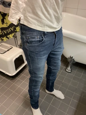 Blå slim fit jeans från Levis  - Säljer ett par blå slim fit jeans från Levis Jeans med klassisk femficksmodell och snygga slitningar. Jeansen har normalhög midja, smal passform och är tillverkade i stretchigt denim för extra komfort. Perfekta till en avslappnad stil. Väldigt skinny 