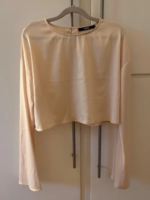 Beige tröja med knappar - Beige tröja med knappar bak, ganska kort men väldigt fin. Armarna är vida längst ner