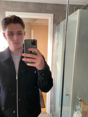 Svart jacka med dragkedja märke selected  - Snygg svart jacka med klassisk krage och silverfärgad dragkedja framtill. Jackan har en clean look och knappar vid ärmsluten. Perfekt till vardags för en stilren outfit.