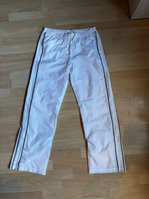 Vita vinted Nike byxor med svarta ränder - Vinted tunna Nike byxor. Perfekta till sommaren och varma dagar där man vill ha lång byxor. Clean look och i bra skick. Bara att skriva vid frågor:)