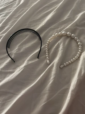 Fyra snygga diadem i olika stilar - Säljer ett paket med fyra diadem: ett svart plastdiadem med kammar, ett pärlbestrött diadem med vita pärlor, ett ljust lila tygdiadem med knut och ett glittrigt diadem täckt av små strass. Perfekt för att variera din look och matcha olika outfits.