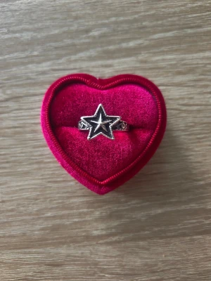 Silverfärgad ring med svart stjärna - ring i storlek 19,4mm, silverfärgad. 