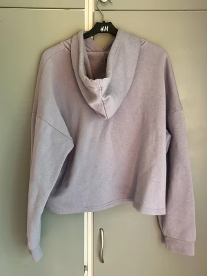 Ljuslila hoodie från ONLY - Mysig ljuslila hoodie från ONLY med huva och dragsko. Hoodien har en avslappnad passform och är tillverkad i mjukt material, perfekt för en chill och avslappnad stil. Insidan är fleecefodrad för extra komfort. Storlek L men passar för mig som brukar ha M