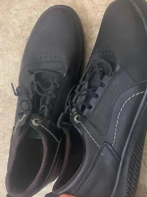 Svarta Timberland loafers i läder - Säljer ett par svarta loafers från Timberland i äkta läder med vita kontrastsömmar och snörning. Skorna har klassisk seglarsko-look och robust sula, perfekta för en stilren och avslappnad vibe.