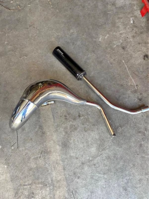 Avgassystem till cross eller moped - Säljer ett avgassystem med böjd kromad expansionskammare och svart ljuddämpare. Passar till cross eller moped. Tillverkad i metall med blank finish och svetsade fogar. Perfekt för dig som vill uppgradera ljud och prestanda på ditt fordon.
