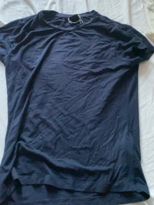 Mörkblå basic t-shirt - En enkel mörkblå t-shirt i mjukt material. Klassisk rund halsringning och korta ärmar. Perfekt till en matchande mörkblå kjol eller jeans. S-M