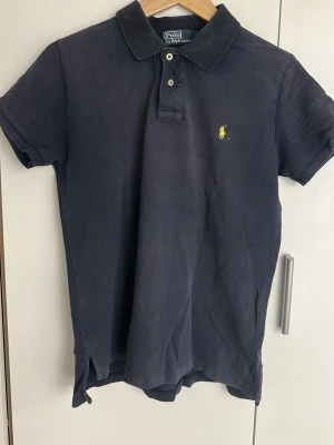 Polo Ralph Lauren Piké Blå Strl M - Säljer en blå Polo Ralph Lauren piké i fint skick.  Klassisk modell som passar till allt. Bekväm passform och tidlös stil.  Storlek: M Färg: Blå  Skickar gärna fler bilder vid intresse.