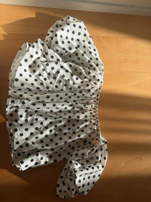 Prickig offshoulder blus med puffärm - köpt på Karlaplan loppis 💕Trendig vit offshoulder blus med svarta prickar och en stor puffärm. Blusen har resår vid axlarna för en snygg passform och luftig känsla. Perfekt för dig som vill sticka ut med en unik och lekfull stil. Materialet känns lätt och bekvämt.