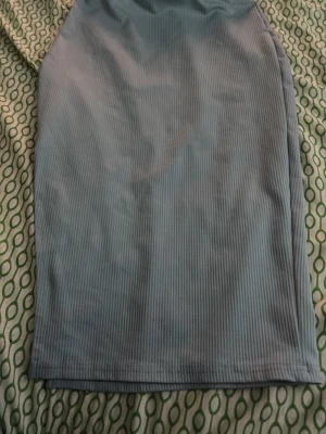 Ljusblå ribbad kortkjol - Säljer en ljusblå ribbad kortkjol med enkel och stilren design. Kjolen har en rak passform och är gjord i ett mjukt, stretchigt material som sitter bekvämt. Perfekt att matcha med en crop top eller hoodie.