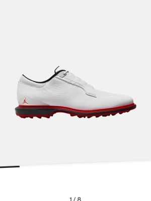 Jordan vit golfskor med röd sula - Snygga golfskor från Jordan i vitt läder med svart och röd detalj på sulan. Skorna har klassisk snörning, låg profil och den ikoniska Jumpman-loggan på hälen. Perfekta för dig som vill sticka ut på golfbanan. Nya kostar 2200kr säljer för 1200kr