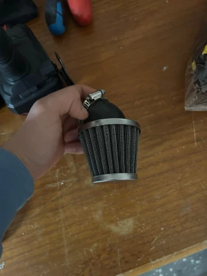 Universalt luftfilter till fordon - Säljer ett konformat luftfilter med metallnät och svart gummibas. Passar till olika fordon och har metallklämma för enkel montering. Perfekt för dig som vill uppgradera luftintaget på din moppe, MC eller bil.