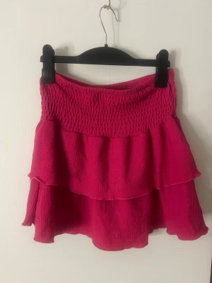 Rosa volangkjol med smock - Superfin kort rosa kjol med volanger och smock i midjan från Gina tricot, storlek 146-152