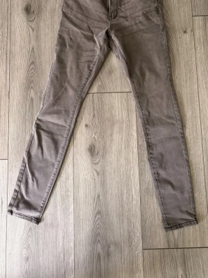 Grå skinny jeans high waist 40 - Snygga grå skinny jeans från Denim med high waist och curved passform. Jeansen har smala ben och klassisk femficksdesign, perfekta för en trendig och bekväm look. Färg: grå. Modell: skinny fit/curved.