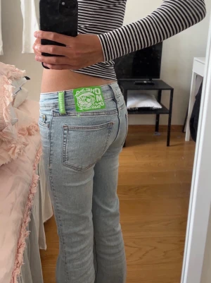 Cheap Monday ljusblå raka jeans - Säljer ett par ljusblå bootcut lowwaist jeans från Cheap Monday med  en grön cheapmonday-logga bak.                             Hör av om bilder och frågor!❣️🫶