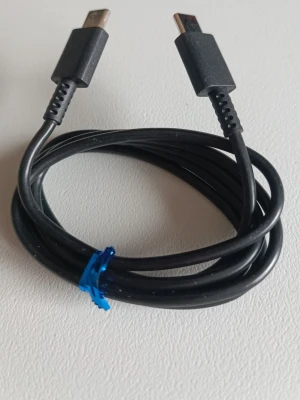 Svart USB-C till USB-C kabel 1m - En svart USB-C till USB-C kabel, perfekt för laddning och dataöverföring mellan kompatibla enheter. Kabeln är flexibel och har robusta kontakter i plast. Passar till de flesta moderna smartphones, surfplattor och laptops med USB-C port.