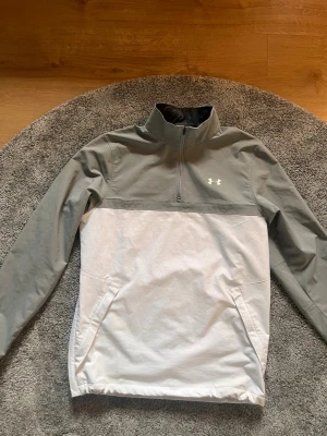 Under armour vindbreaker - Snygg vindjacka i färgerna grå och svart med det klassiska under armour loggan på bröstet. Jackan  är i mycket god skick. Perfekt för dig med god stil🤩