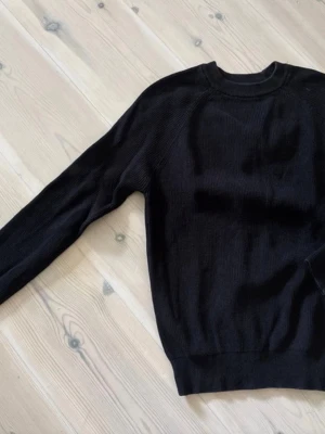 Svart stickad tröja från Zara - En stilren svart stickad tröja från Zara med rund halsringning och ribbade muddar.Storlek S men sitter mer som xs. Tröjan har lång ärm och är tillverkad i ett mjukt, tunt stickat material som passar perfekt till lager-på-lager. Enkel och clean design som funkar till allt.