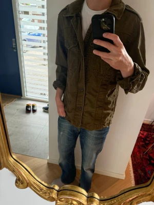 Sjukt fet overshirt från Abercrombie & Fitch - Säljer en olivgrön overshirt med klassisk krage och stora bröstfickor. Jackan har knappar framtill och är tillverkad i ett slitstarkt bomullstyg. Perfekt för lager på lager och har en avslappnad, loose passform. Är i storlek S men passar mig som är 187
