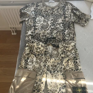 Beige camo t-shirt och shorts från Stone Island - Limited edition alligator camo set av Stone Island från 2018 i ett grymt skick. Kan köpas styck också. T-shirt storlek M och shorts 32