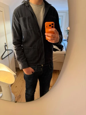 Mörkblå overshirt - Overshirten är i överlag bra skick förutom att lappen är lite sliten och de är en knapp som saknas på ärmen