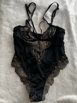 Svart spetsbody med brodyr - Lexi Body Caviar. Ny pris 400kr.