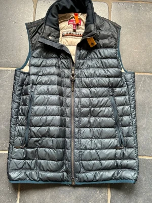 Blå väst från Parajumpers - Säljer nu denna riktigt snygga  parajumper västen i mörkblå färg!  Köpte den för några år sedan på NK men har knappt använt den så skicket är 9/10. Storlek M, nypris 3599kr. Mitt pris: 1750. Hör av er om ni har funderingar!