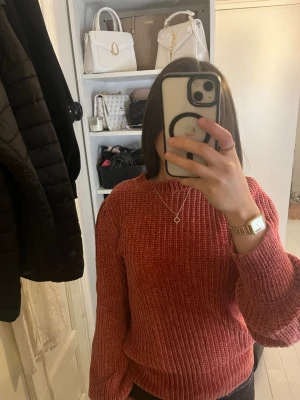 Roströd ribbstickad tröja - Mysig roströd stickad tröja med bred ribbstickning och ballongärmar. Tröjan har rund halsringning och är något kortare i modellen. Perfekt för lager på lager och ger en trendig look till hösten och vintern.