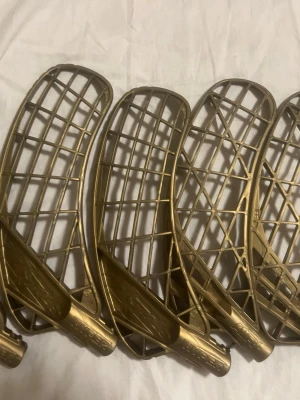 Guld blad  - Säljer fyra guldiga innebandyblad från Zone. Bladen är tillverkade i plast och har ett klassiskt rutmönster för bra bollkontroll. Perfekt för dig som vill sticka ut på planen med en unik färg. Passar de flesta innebandyklubbor med standardfäste.3 Hyper bals och 2 air one.    Pris kan diskuteras vid snabb affär. 75kr st original pris 177 kr st 