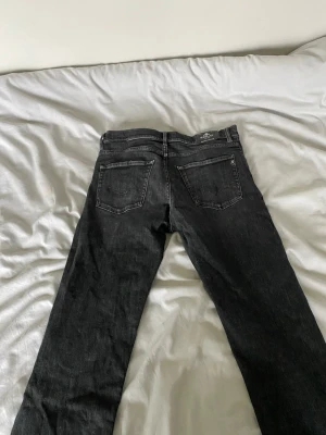 Svarta jeans från Replay  - Snygga svarta jeans från Replay med klassisk femficksdesign och raka ben. Jeansen har en diskret tvättad look och är tillverkade i ett mjukt denimtyg. Perfekta för dig som gillar stilrena och tidlösa jeans.