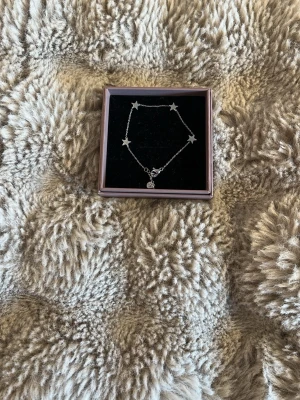 Stjärnarmband i silver från Edblad - Snyggt armband i silverfärgad metall från Edblad med flera små stjärnor längs kedjan. Levereras i originalask. Armbandet är i väldigt bra skick😊! Orginalpris: 399, mitt pris: 299