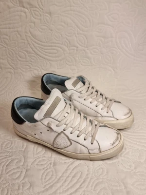 Philippe model  - Hej, säljer nu ett par riktigt snygga par philippe models som är perfekta nu inför våren/sommaren. Skorna är generellt i gott skick, dick har den än mindre skada på vänstra skons yttersula. Det har ingen större påverkan och är knappast synligt med skon på. Hör av er om ni har ytterligare frågor!