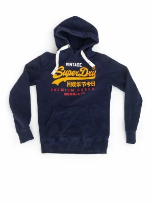 Mörkblå Superdry hoodie med tryck - Snygg mörkblå hoodie från Superdry med gul och röd vintage-tryck framtill och japanska tecken. Klassisk känguruficka, vit dragsko i huvan och mjukt material. Stor storlek S (M)
