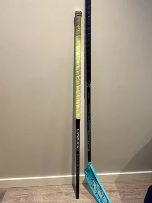 Unihoc Superskin innebandyklubba - Unihoc Superskin innebandyklubba i svart med vit och blå logga samt gult grepplinda och en oxdog x5. Tillverkad i lätt material för smidig hantering på planen. Perfekt för dig som vill ha bra kontroll och känsla i spelet. Dom båda är i 100cm och 300kr för unihoc skaftet 600kr för oxdogen och vid köp av båda 800kr