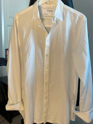 Vit linneskjorta från Selected Homme - Vit linneskjorta från selected homme i storlek M. Skjortan är helt oanvänd och den säljs då den är något för stor för mig. Nypris cirka 700 kr.