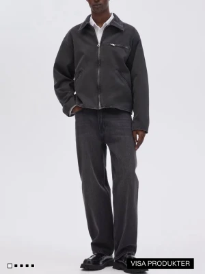 Svarta jeans från H&M - Säljer ett par svarta raka jeans från H&M  med klassisk femficksmodell och hög midja. Jeansen har en avslappnad passform och är tillverkade i kraftig denim. Perfekta för en clean och stilren look.