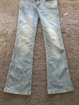 Ljusblå jeans med broderade fickor - Snygga lågmidjade ljusblå jeans från Lager 157 med utsvängda ben och coola broderade detaljer på bakfickorna. Perfekta för en avslappnad och trendig look.