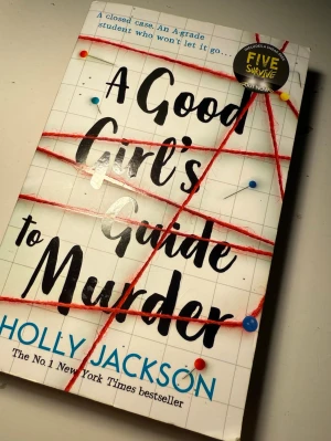 A Good Girl's Guide to Murder - Spännande ungdomsroman med vit framsida, svarta och blå bokstäver och röd tråd som motiv. Boken är skriven av Holly Jackson och är en bästsäljare inom deckare och mysterier. Perfekt för dig som gillar nervkittlande berättelser. På engelska 