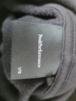 Svart sweatshirt Peak Performance - Klassisk svart sweatshirt från Peak Performance med rund hals och ribbade muddar vid ärmslut och midja. Tröjan är enkel och stilren, perfekt för en avslappnad look. Tillverkad i mjukt material för extra komfort. Använd 3 gånger