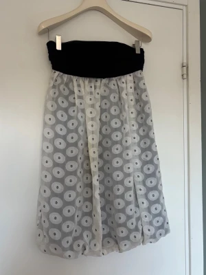 Svart och vit klänning med prickar - Snygg bandeuklänning med svart, rynkad topp och vitt, transparent tyg med prickar. 