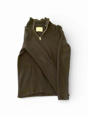 Svart halv zip Jack & Jones - Svart ribbstickad tröja från Jack & Jones med halv dragkedja och hög krage! Tröjan har långa ärmar och är tillverkad i ett mjukt, stretchigt material! Perfekt för dig som vill ha klassisk och stilig look😎