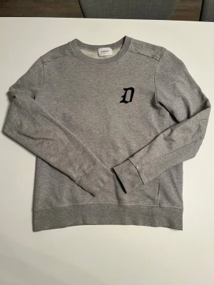Grå sweatshirt från Dondup - Tvärfet grå sweatshirt från dondup i storlek S.          Tröjan är nästintill oanvänd med en liten slitning på vänster ärm (se på bild).                                                     Hör av dig om du har frågor! 💭                                 Modell är 183cm 68kg 💫 