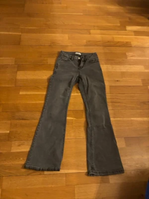 Grå bootcut jeans med fickor - Snygga grå jeans med bootcut-modell och klassiska fem fickor. Jeansen har normal midja och raka ben som blir vidare nedtill. Perfekta för en avslappnad men trendig look. Materialet är denim i bomull.