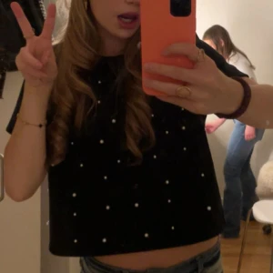 Svart topp med pärlor!! - Säljer denna jättefina topp från H&M!! Super skick och nästan aldrig använd. Säljer pga den inte kommer till användning. Skriv för frågor 